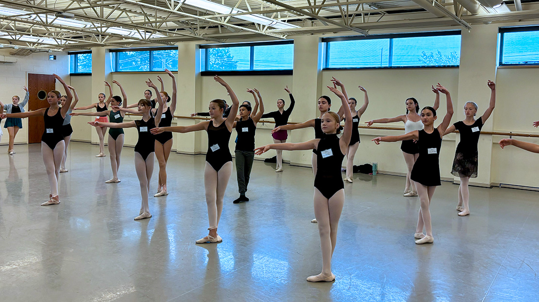 Dancers stand in fifth position, preparing to begin a ballet center combination at Webster's 2024 Junior Summer Dance Intensive.