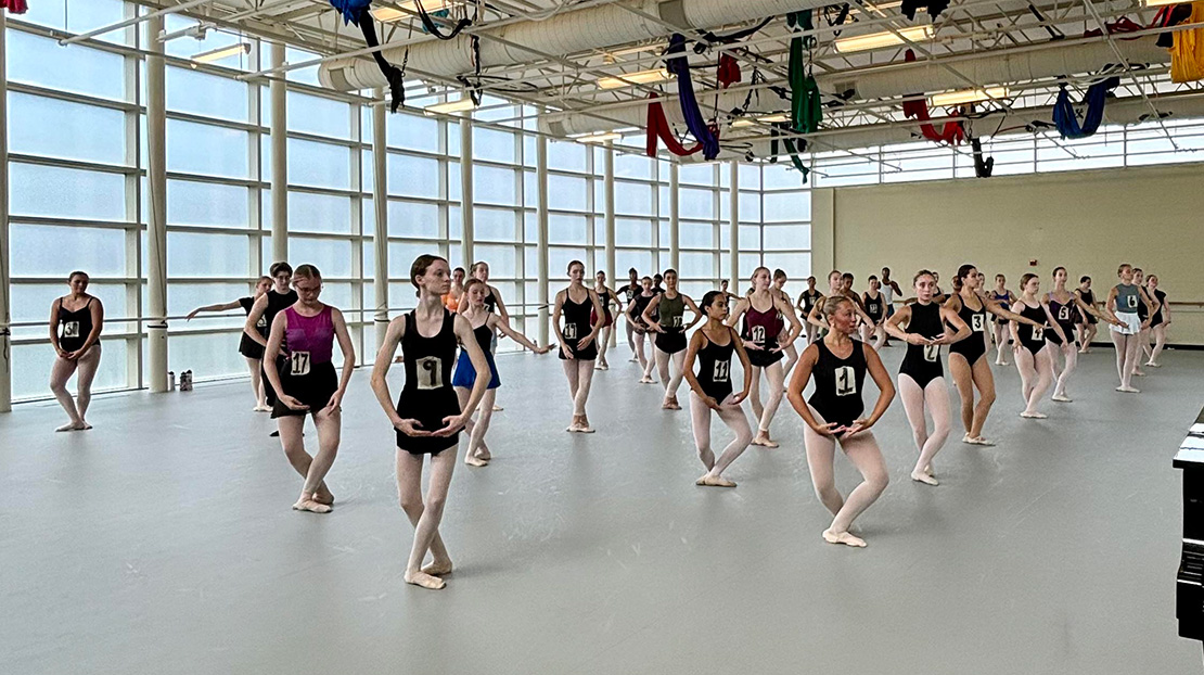 A group of students take a ballet class in Webster's large dance studio during the 2024 Senior Summer Dance Intensive.