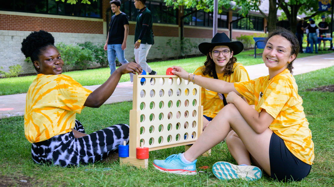 A group of Webster Students playing a lawn-size game of connections.