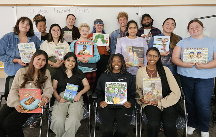 group of student tutors holding children's books