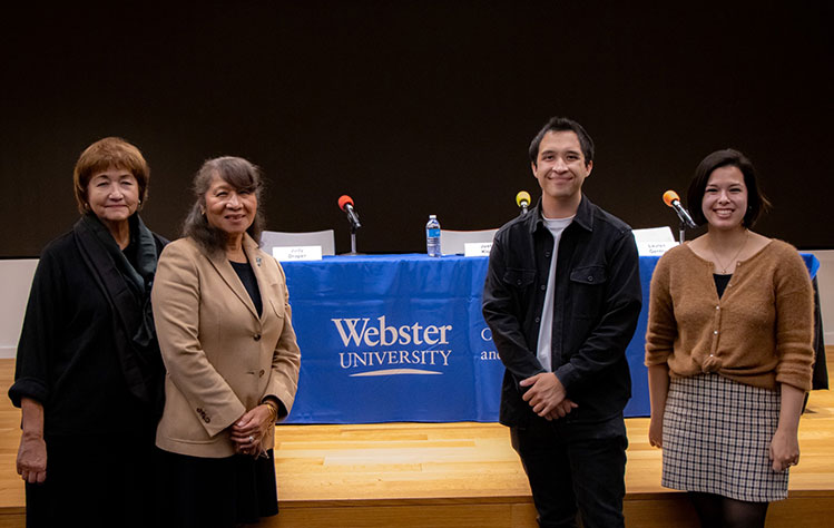 Panelist pose in front of the stage in the ISB Auditorium. Left to right: Moderator Anna Crosslin and panelists Judge Judy Draper, Justin Klos and Lauren Gentry.  