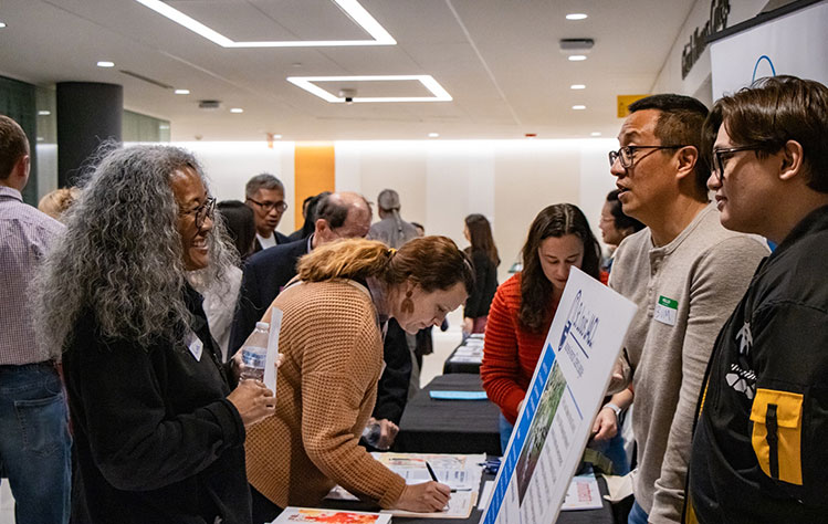 Guests attend the community resource fair featuring local AAPI organizations in the hallway outside of the ISB auditorium.  