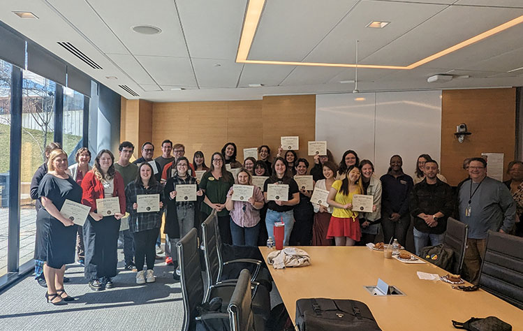 Recipients of the College of Humanities and Social Sciences pose for a photo with their certificates and instructors. 