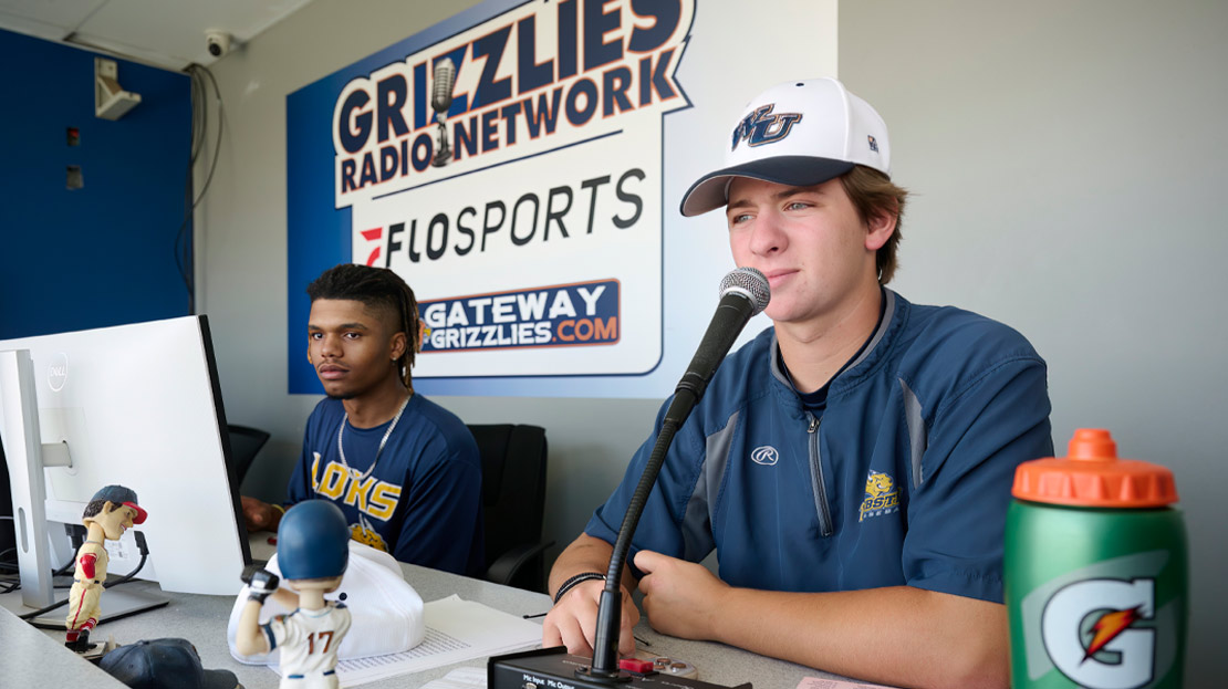 Two students announcing at a baseball game.